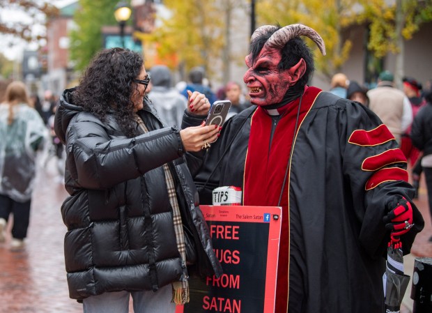 Teo Source, of Boston, reaches for a hug from Salem Satan on Sunday.